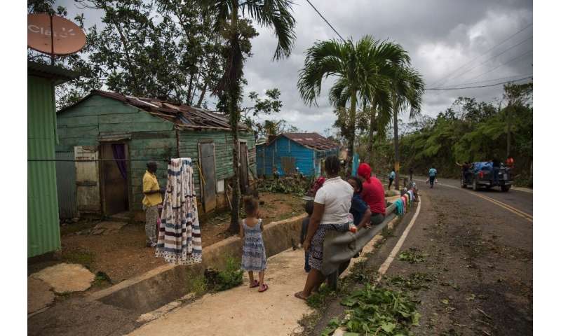 Residents are seen outside their homes in northeast Dominican Republic on September 21, 2022 after the passage of Hurricane Fion