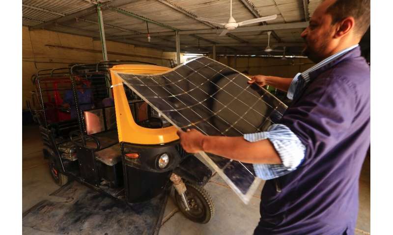Workers assemble electric tuk-tuks in Khartoum: the tricycles take around eight hours to fully charge