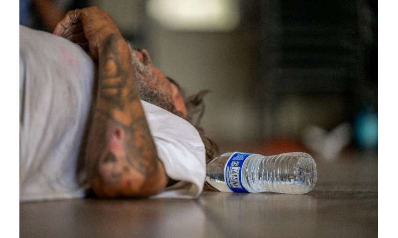 A man exhausted by the scorching heat takes a rest at a Phoenix church in Arizona in July 2023