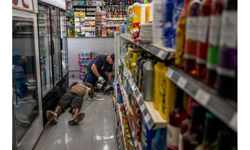 A man is given medical aid after collapsing from the heat in a Phoenix supermarket in July 2023 in Arizona