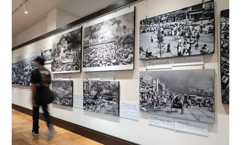 A visitor walkis past images on display from the 1923 earthquake and resulting fire which killed over 100,000 residents of Tokyo