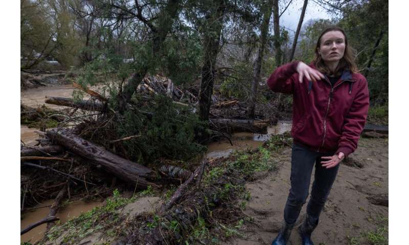 Amberlee Galvin stands next to evidence of the flooding that has ravaged the town of Felton