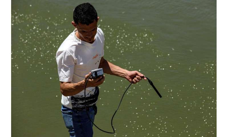 An Iraqi government official measures the oxygen level and salinity of the water of the Amshan river