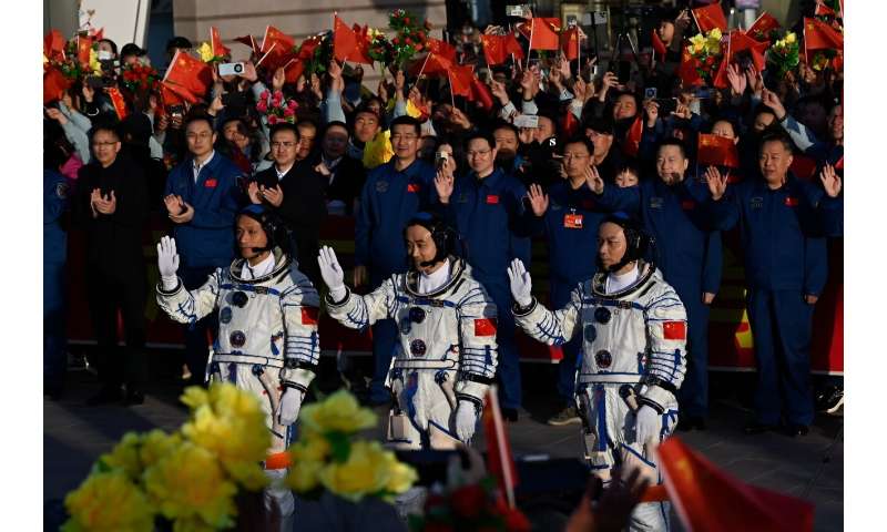 Chinese astronauts Jiang Xinlin, Tang Shengjie and Tang Hongbo wave before boarding the Shenzhou-17 spacecraft on October 26, 2023