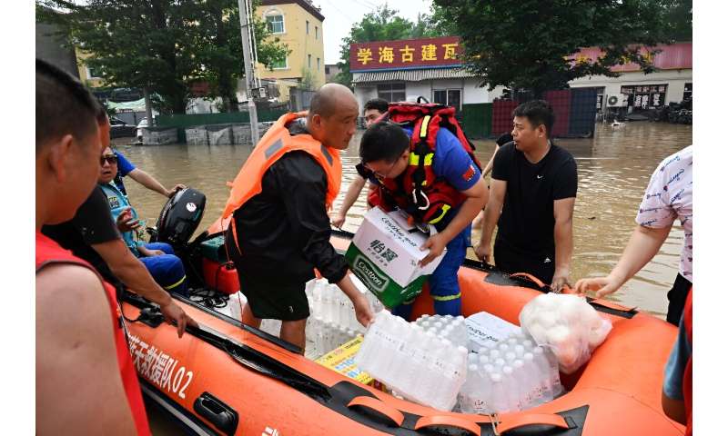 Rescue workers in one part of Zhuozhou visited used boats to transport instant noodles, bread and drinking water to besieged res
