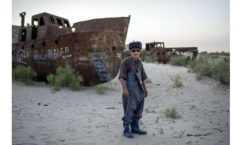 These men once relied on the Aral Sea. Today, the dry land is a reminder of lost livelihoods