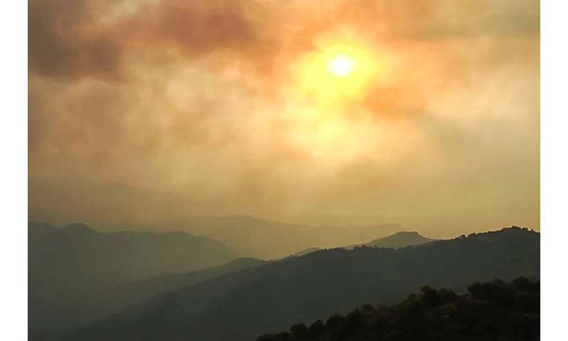 This image grab taken from AFPTV video footage shows smoke clouds covering the sky during wildfires in the forests of Bejaia in 