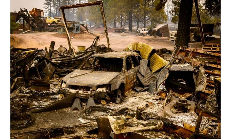 A burned vehicle smolders in Tehama County, California on July 27, 2024