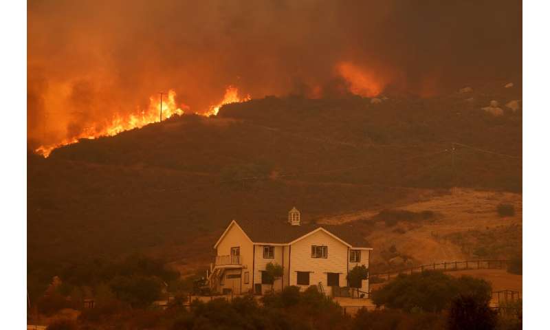 A house is threatened as the Airport Fire gains ground near Lake Elsinore