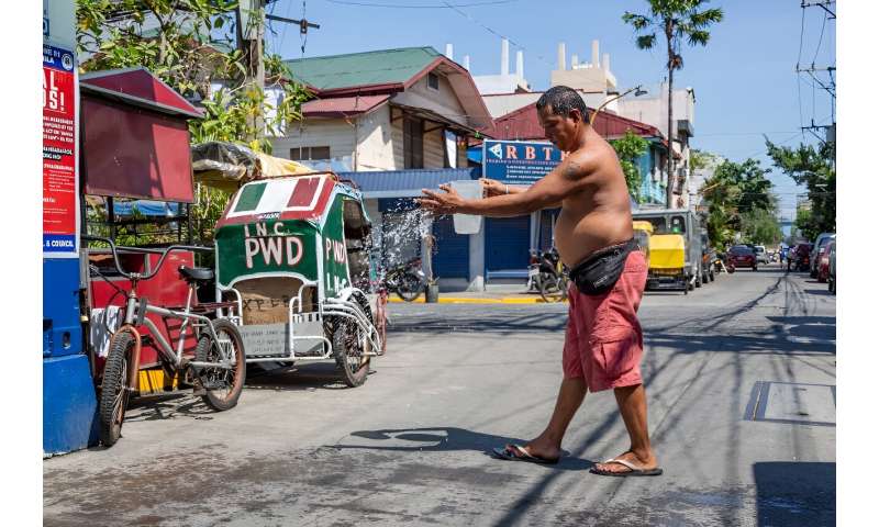 A man douses himself with water during a heatwave in Manila