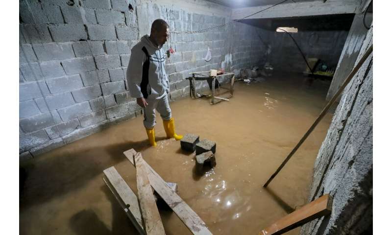 A man stands in the flooded basement of a home