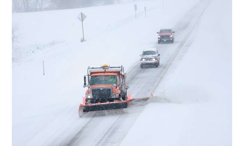 A plow clears Iowa Highway 5 as a snowstorm dumps several inches of snow in Des Moines, Iowa