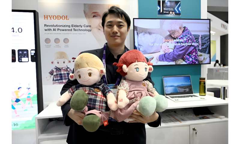 An employee of South Korean company Hyodol holds AI-powered dolls meant to provide companionship to elderly people