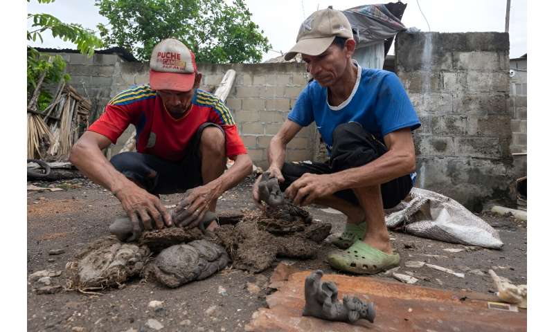 Colombian potters Hugo Osorio (L) and Pedro Fuentes create coral-housing statues with designs based on those of the Zenu people
