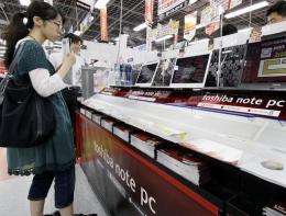 A customer checks Japanese electronics giant Toshiba notebook computers at an electronics shop