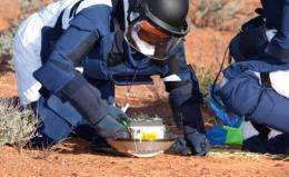 A team of scientists inspect the capsule carried by the Japanese Hayabusa spacecraft after it landed in Australia
