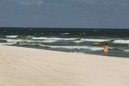 A woman walks the beach in Gulf Shores, Alabama, in 2010