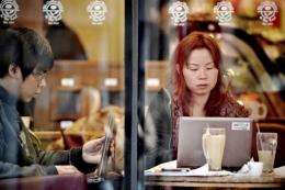 Chinese people surf the Internet using the wi-fi connection of a cafe