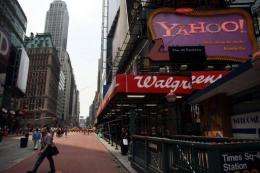Pedestrians walk by a Yahoo sign in Times Square