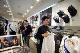 People look at French and English rugby union national team jerseys at the Champs Elysee Nike store