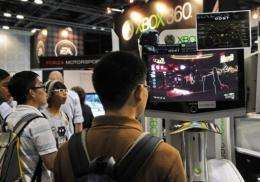 Visitors play the Xbox 360 video games at the Games Convention Asia exhibition in Singapore