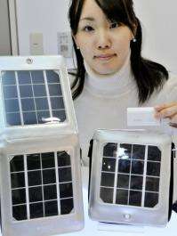 An employee of Japan's electronics giant Sanyo displays their portable solar power generators