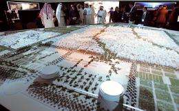 Visitors look at the project model of Masdar City in Abu Dhabi in 2008