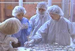 Dr. Eileen Stansbery and other members of the Genesis cleanroom team look at recovered samples