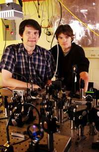 Researchers Thierry Chaneliere and Dzmitry Matsukevich pose with equipment used to demonstrate storage of a single photon in a q