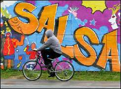 A man rides his bicycle past a colourful mural in the Columbia Heights area of Washington