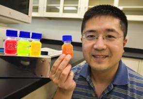 Frank Chen holds a bottle of quantum dots.