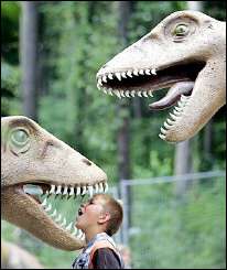 A German youth sticks his head in the mouth of a dinosaur figure