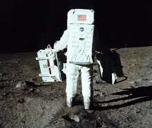 Buzz Aldrin totes experiments from the Eagle onto the lunar surface.