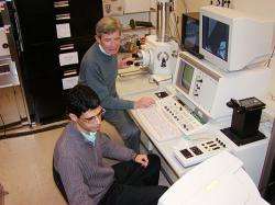 Alireza Nojeh (front) and Fabian Pease use a scanning electron microscope to view carbon nanotubes.