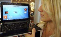 A fair hostess presents a netbook with the new Windows 7 version