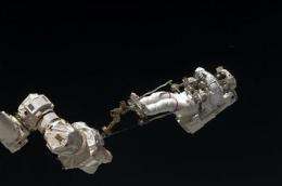 Spacewalking astronauts replace station batteries (AP)