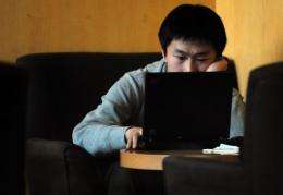 A man surfs the web at a cafe in Beijing, China where two Chinese bloggers have been fined for defamation