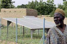 A man pictured next to solar panels in a village in Niger in 2004