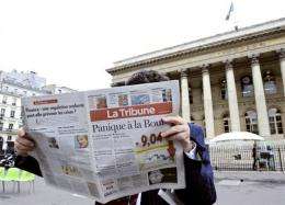 A man reads French economical newspaper La Tribune in front of the Palais Brongniart