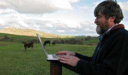 A man works on his laptop at a beef cattle farm near the small Australian town of Harden