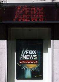 An electronic news ticker above a sign at the Fox News Channel television studios in New York.