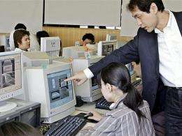 An teacher instructs a student in a Tokyo computer lab