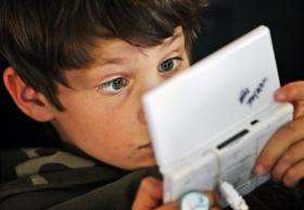 A participant of a game tournament is seen behind his Nintendo DS