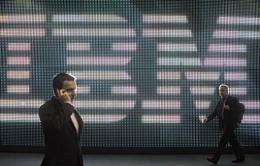 A visitor speaks on his cellphone as he walks past a giant screen near an IBM display