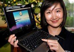 A woman displays a latest Acer UX-30 notebook at Computex Taipei