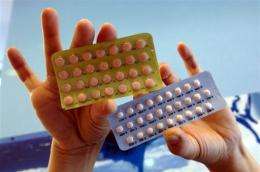 A woman holds two packets of birth control pills
