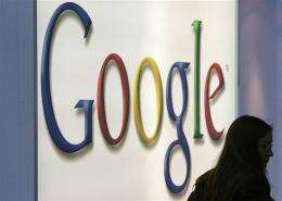 A woman walks past a Google logo