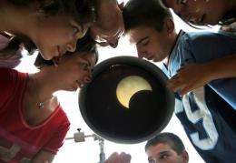 Bulgarian children look at a eclipse of the sun through a telescope in the Black Sea port of Varna