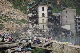 Former residents and tourists look at the damage in the quake-stricken town of Beichuan, China