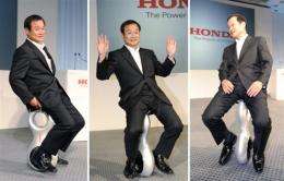 Honda President Takanobu Ito  displays the prototype model of a personal mobility device called the 'U3-X'